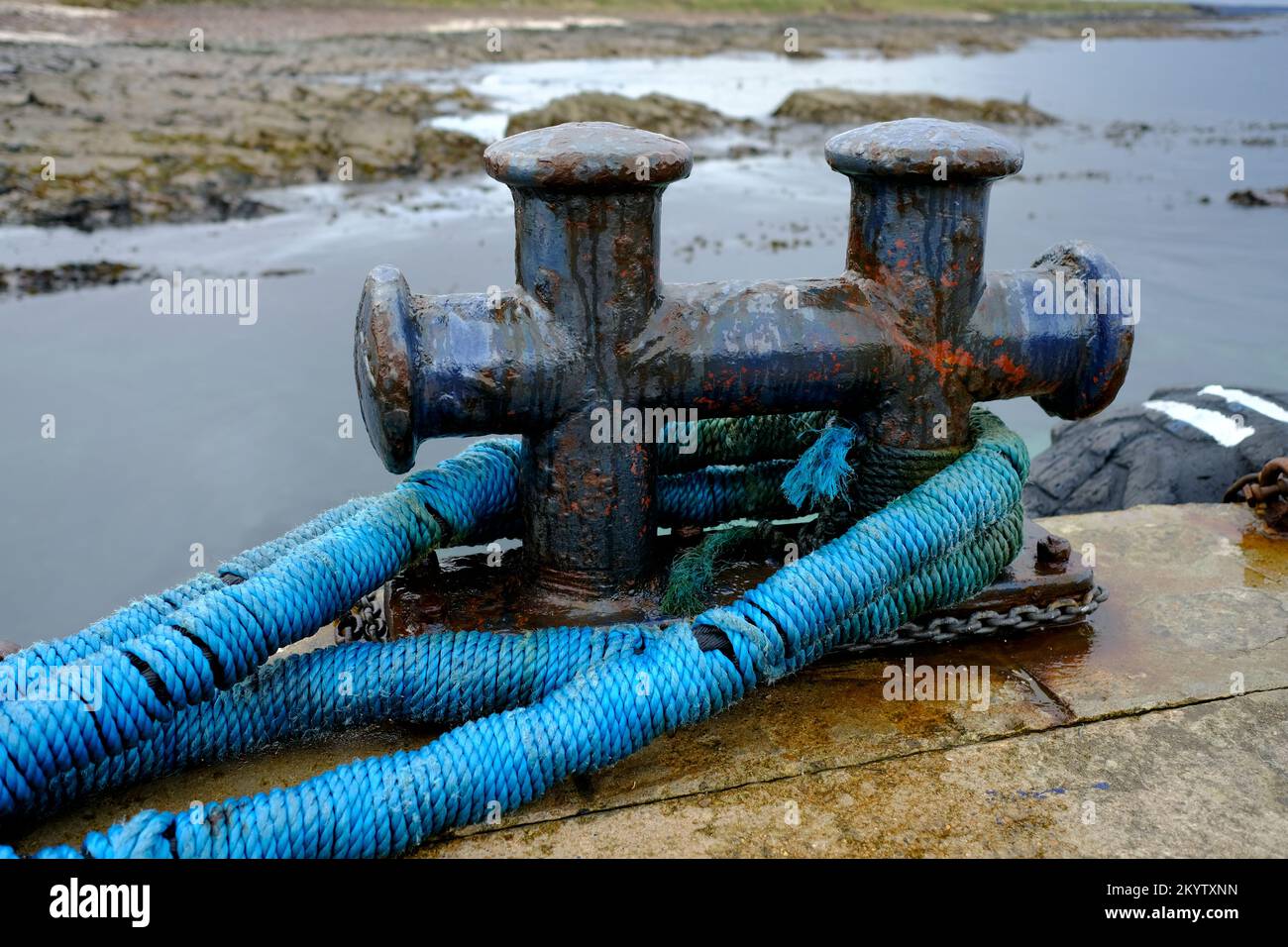 Ship's double mooring bollard with blue ropes attached Stock Photo