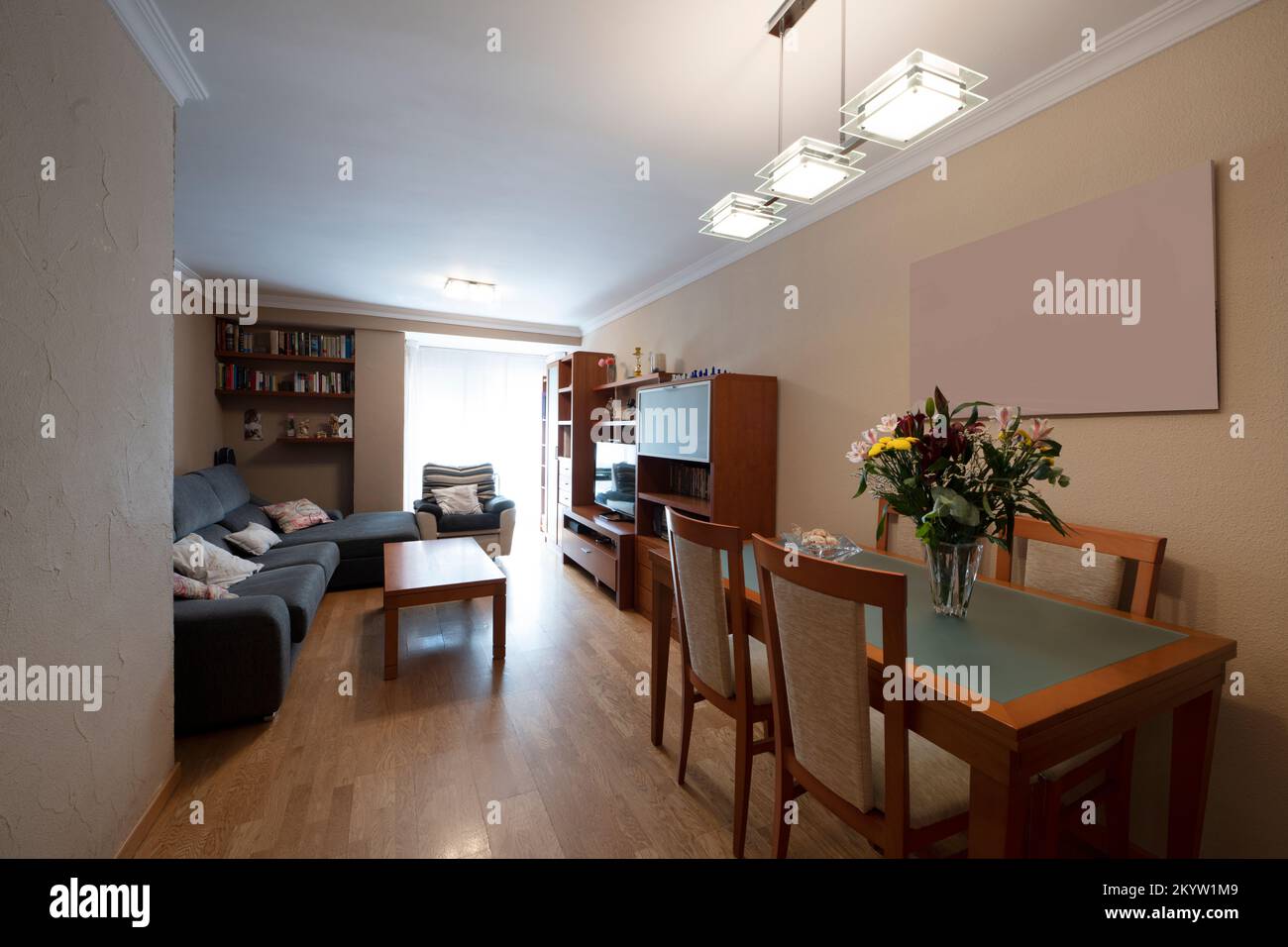 Living room of a house with a dining table with a flower arrangement and matching chairs Stock Photo