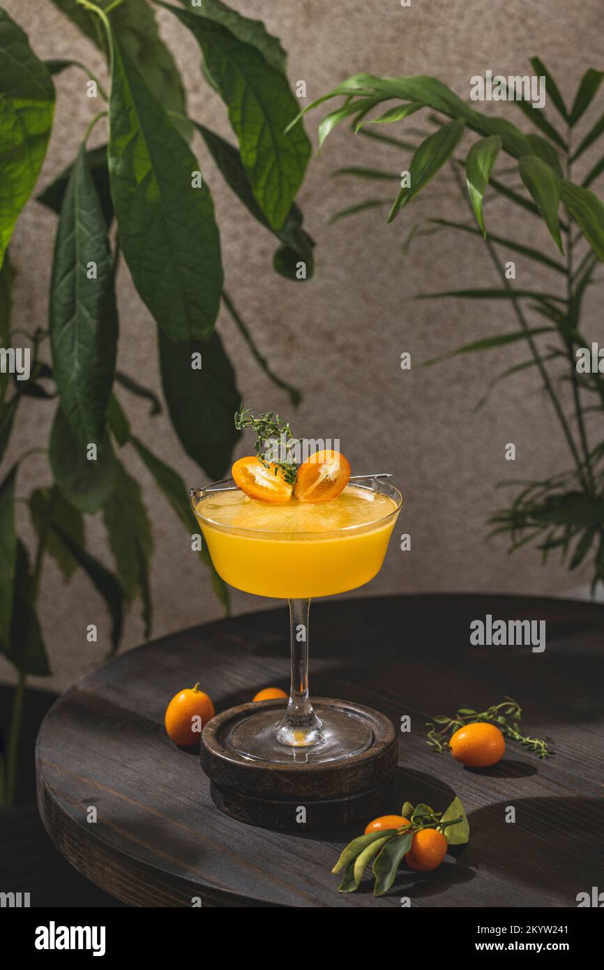 Glass of refreshing Kumquat & Thyme Vodka Cocktaila cocktail surrounded