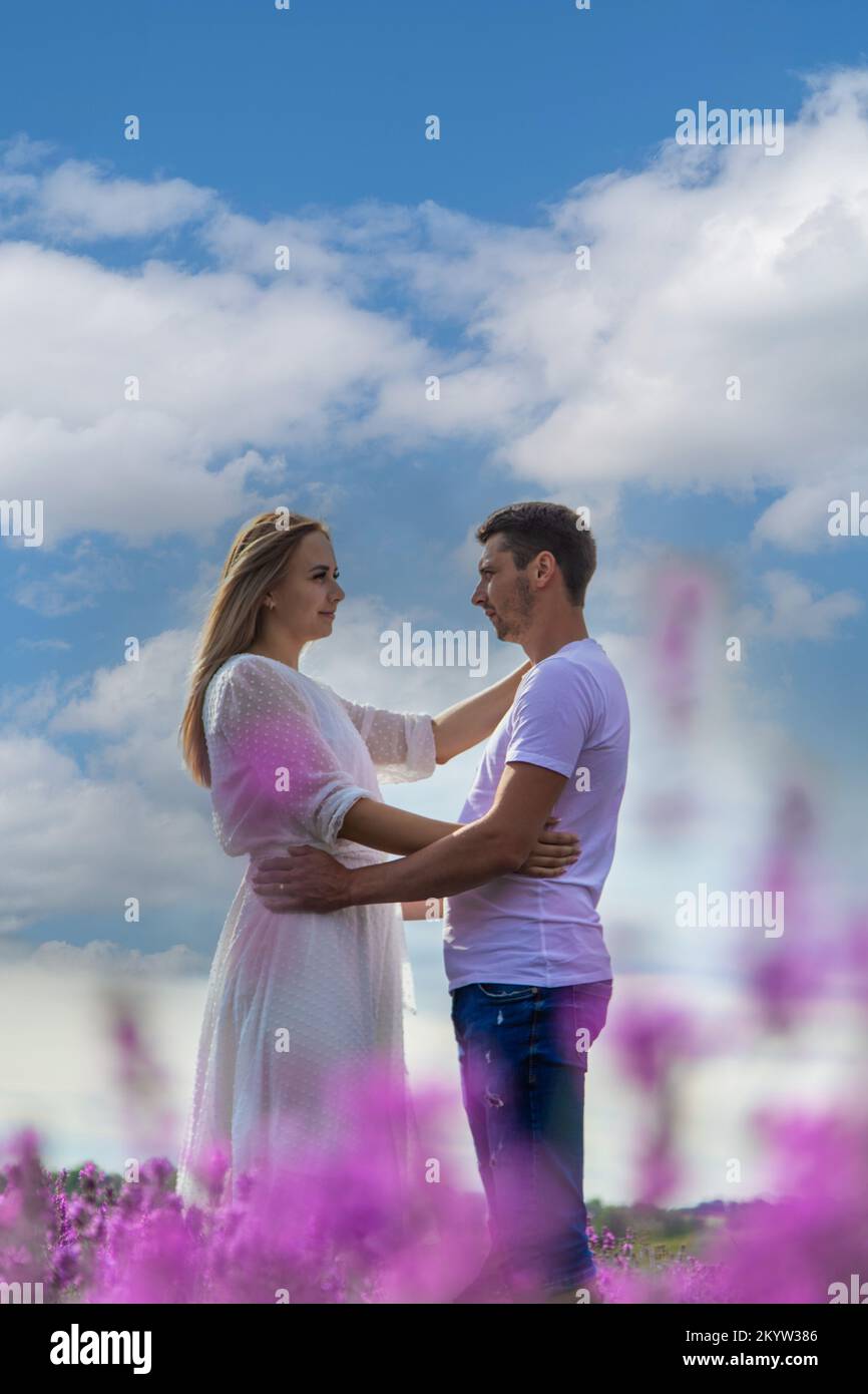Beautiful purple lavender flowers in a summer field. couple holding hands, romantic love story. Stock Photo