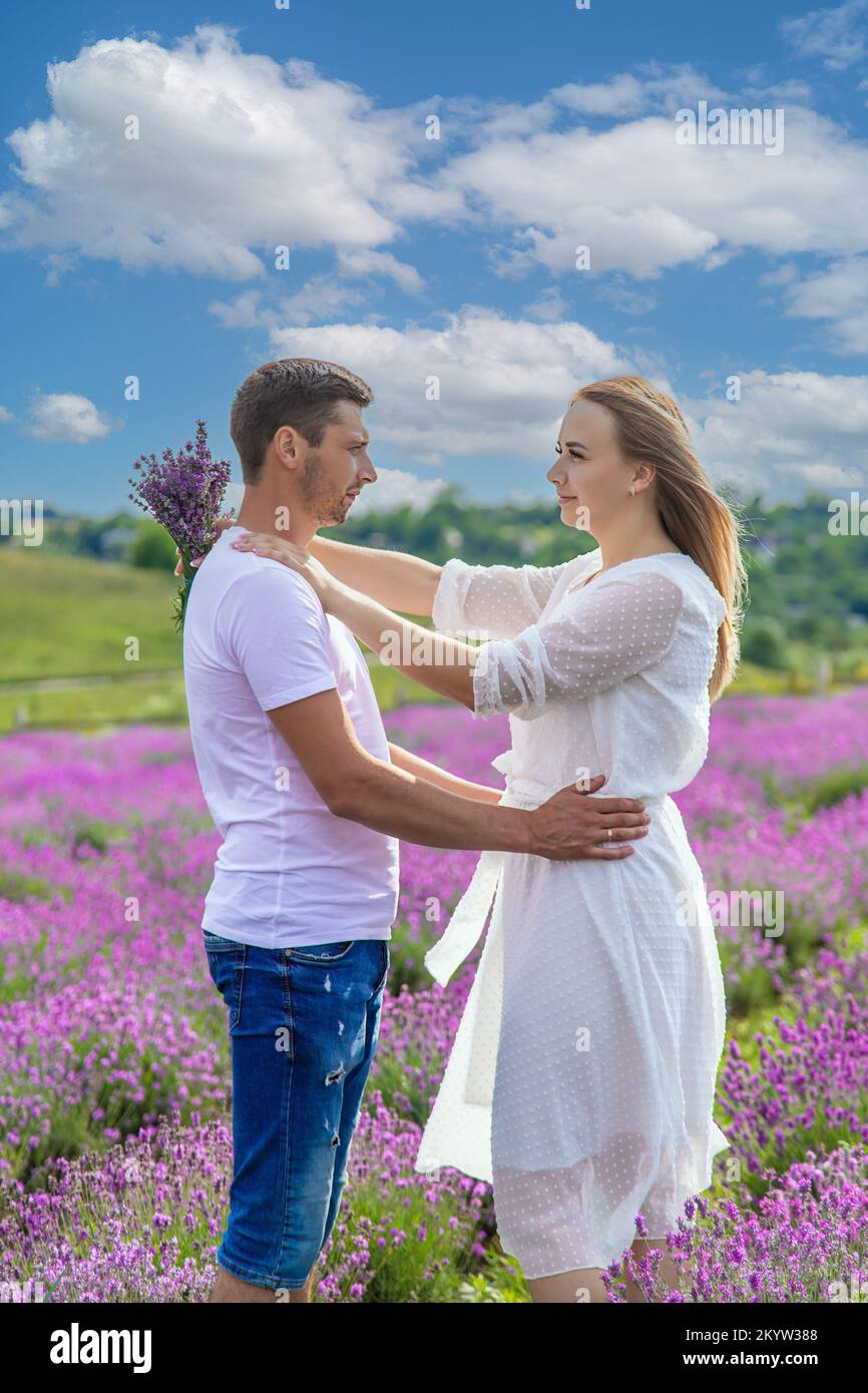 Beautiful purple lavender flowers in a summer field. couple holding hands, romantic love story. Stock Photo