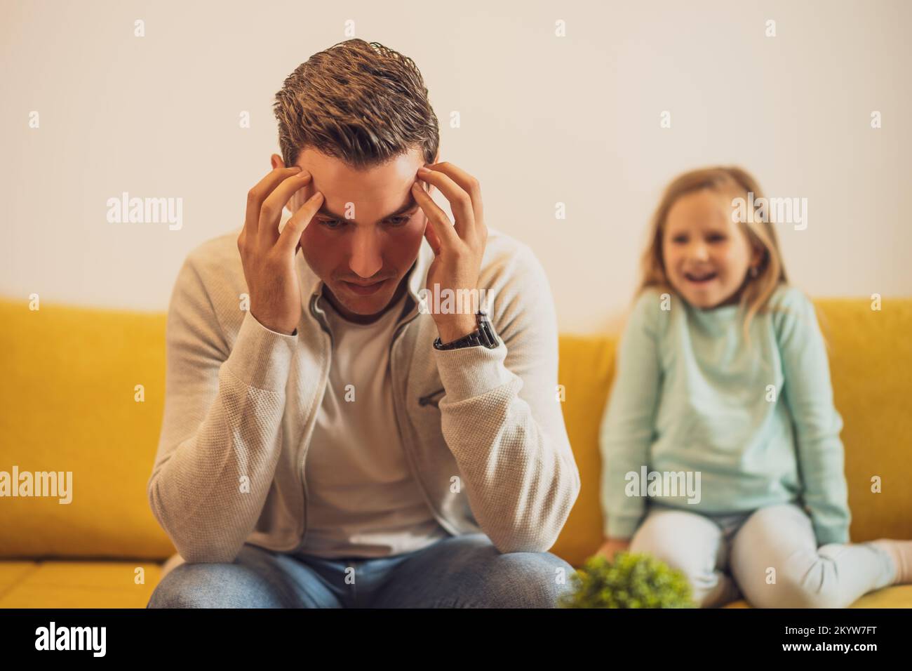 Stressed father is feeling desperate because of screaming his daughter