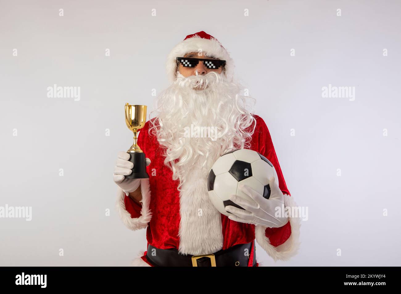 santa claus with sunglasses 'thug life' soccer ball and a trophy in his hand on white background Stock Photo