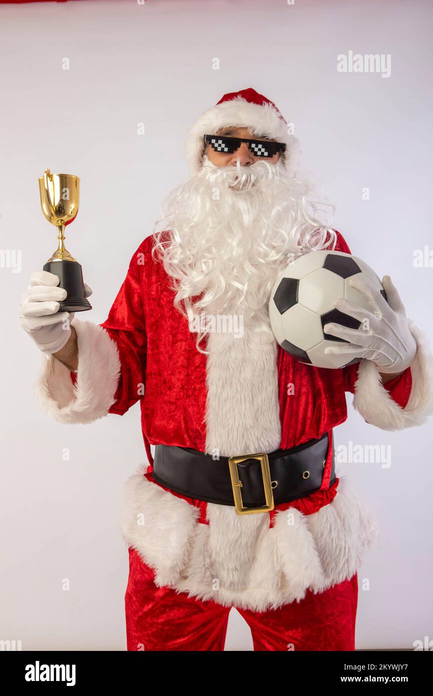 santa claus with sunglasses 'thug life' soccer ball and a trophy in his hand on white background Stock Photo