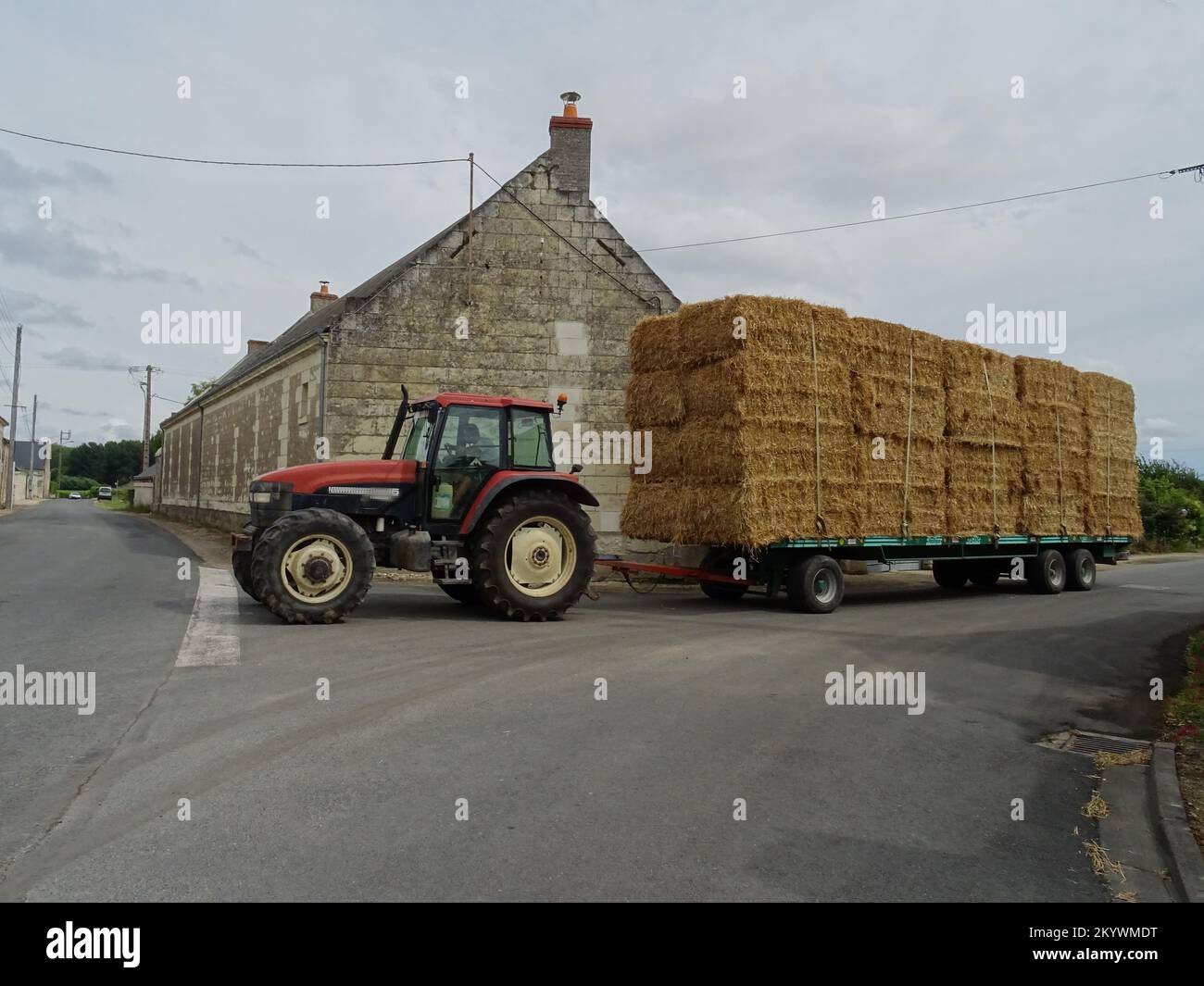 tractor hauling square hay bales in the Loire valley, France in the village Stock Photo