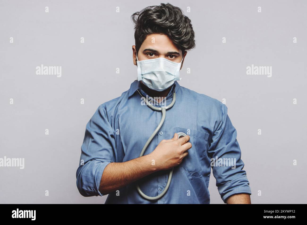 A young millenial doctor checking his own hearbeat. Stock Photo