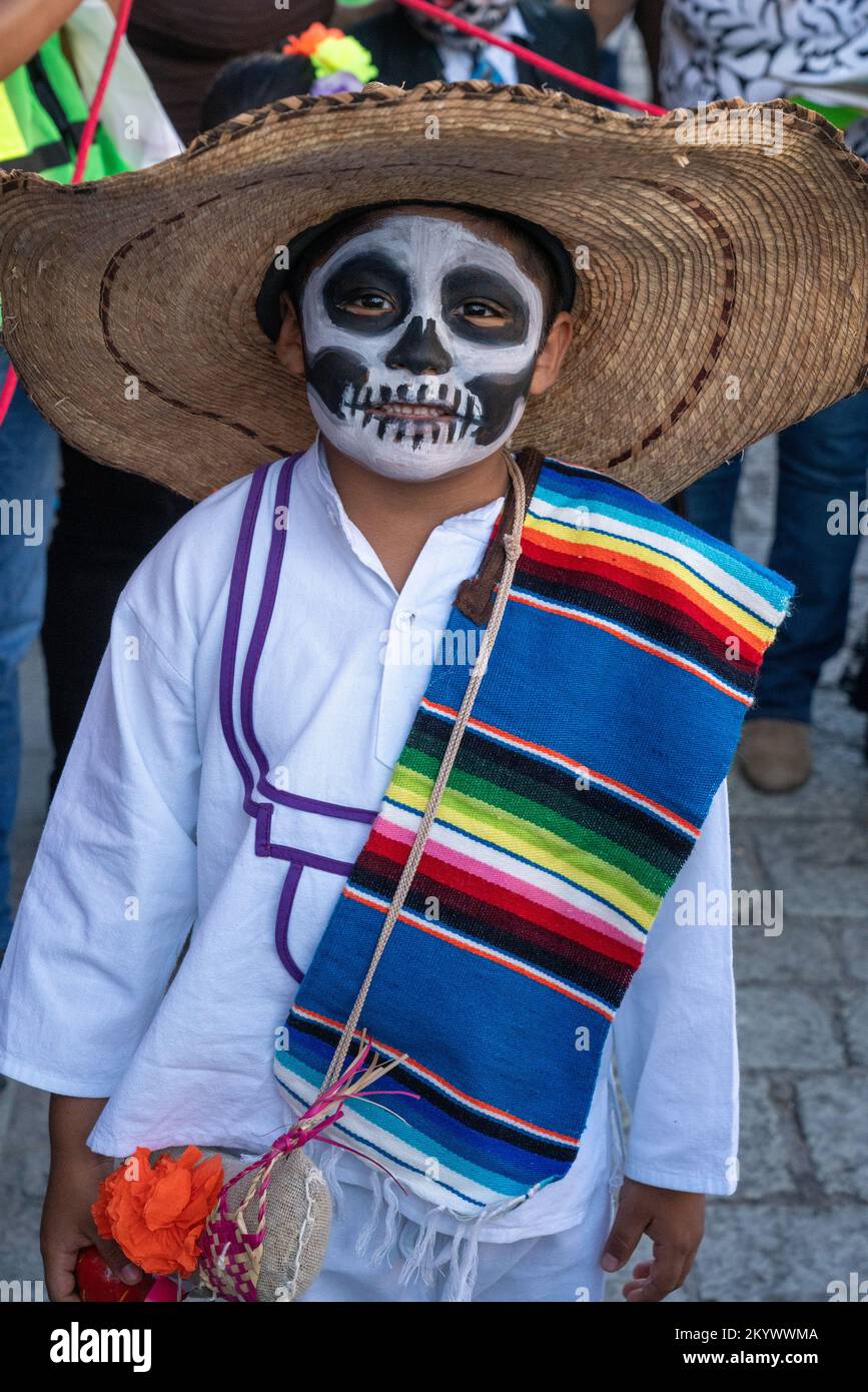 A young boy in a peon costume and face paint for a Day of the Dead children's parade on a street in Oaxaca, Mexico. Stock Photo