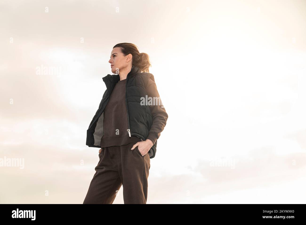 Fit sporty mid adult woman wearing a track suit outside. Preparing for exercise. Stock Photo