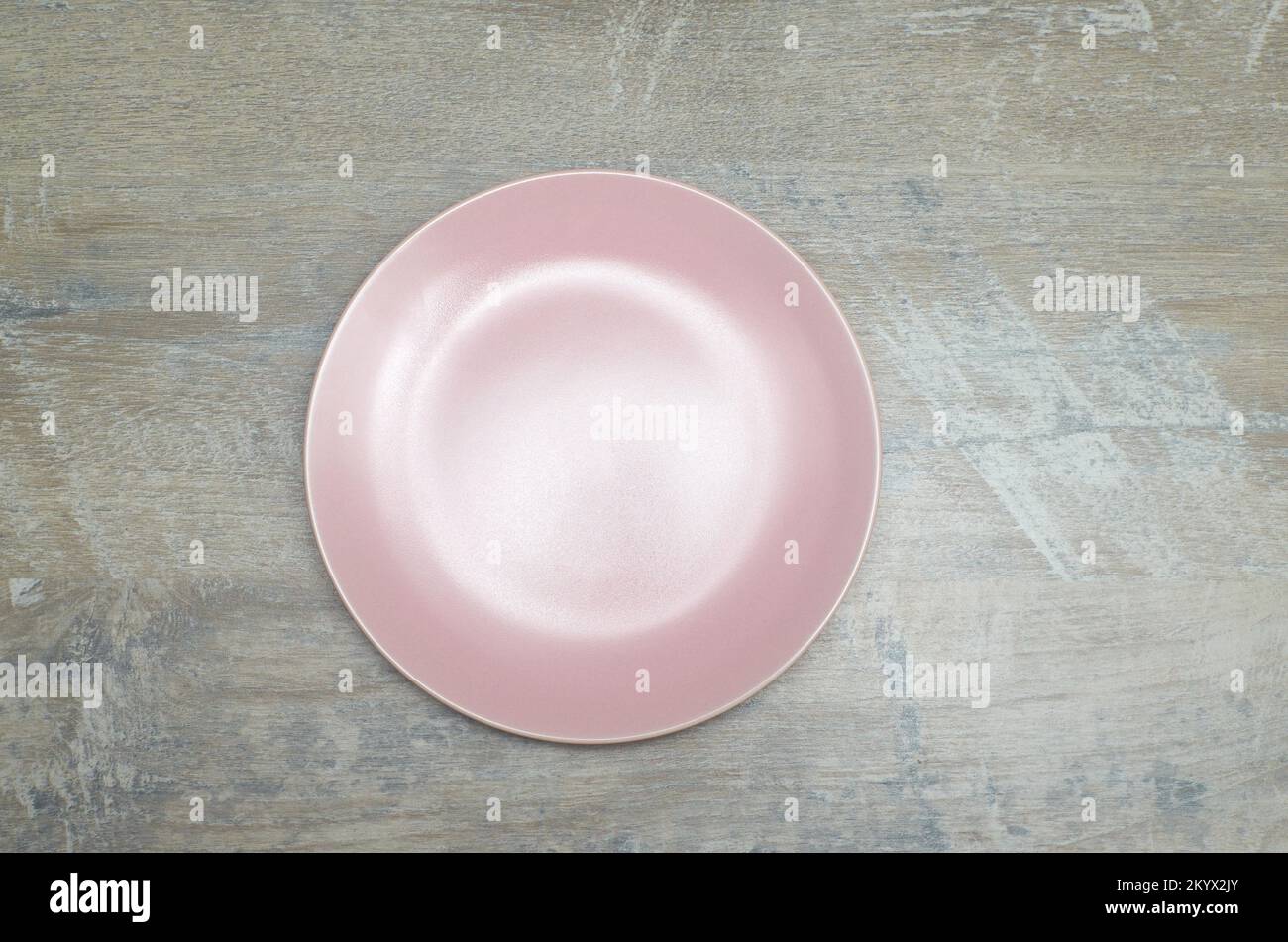 Pink empty plate on a wood pattern surface - top-shot Stock Photo