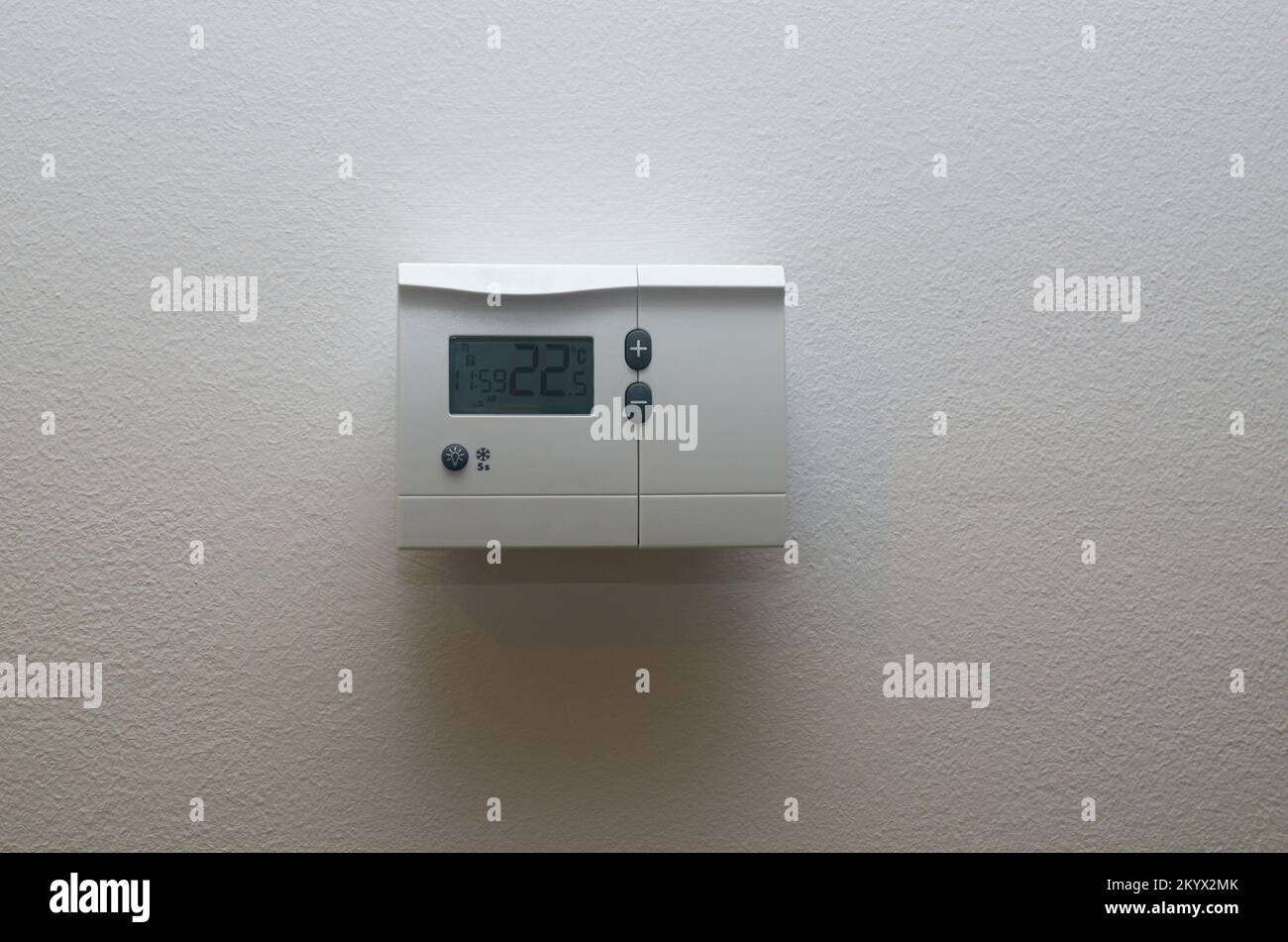 White temperature unit for apartment heating on a white door Stock