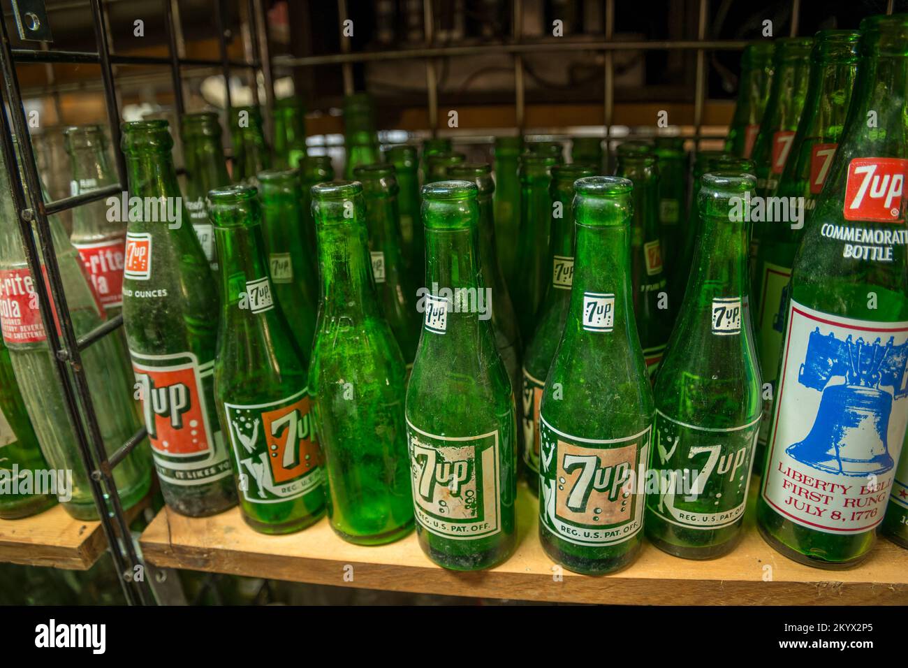 Worn and weathered antique 7-up bottles grouped together on a shelf closeup view Stock Photo