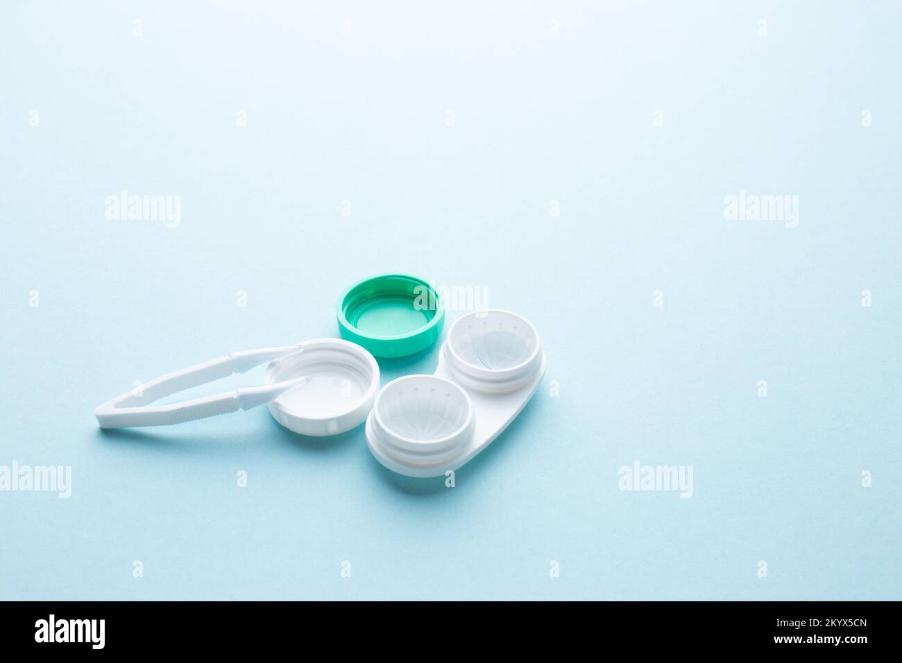 Contact lenses and accessories container for lenses and tweezers on a blue background Stock