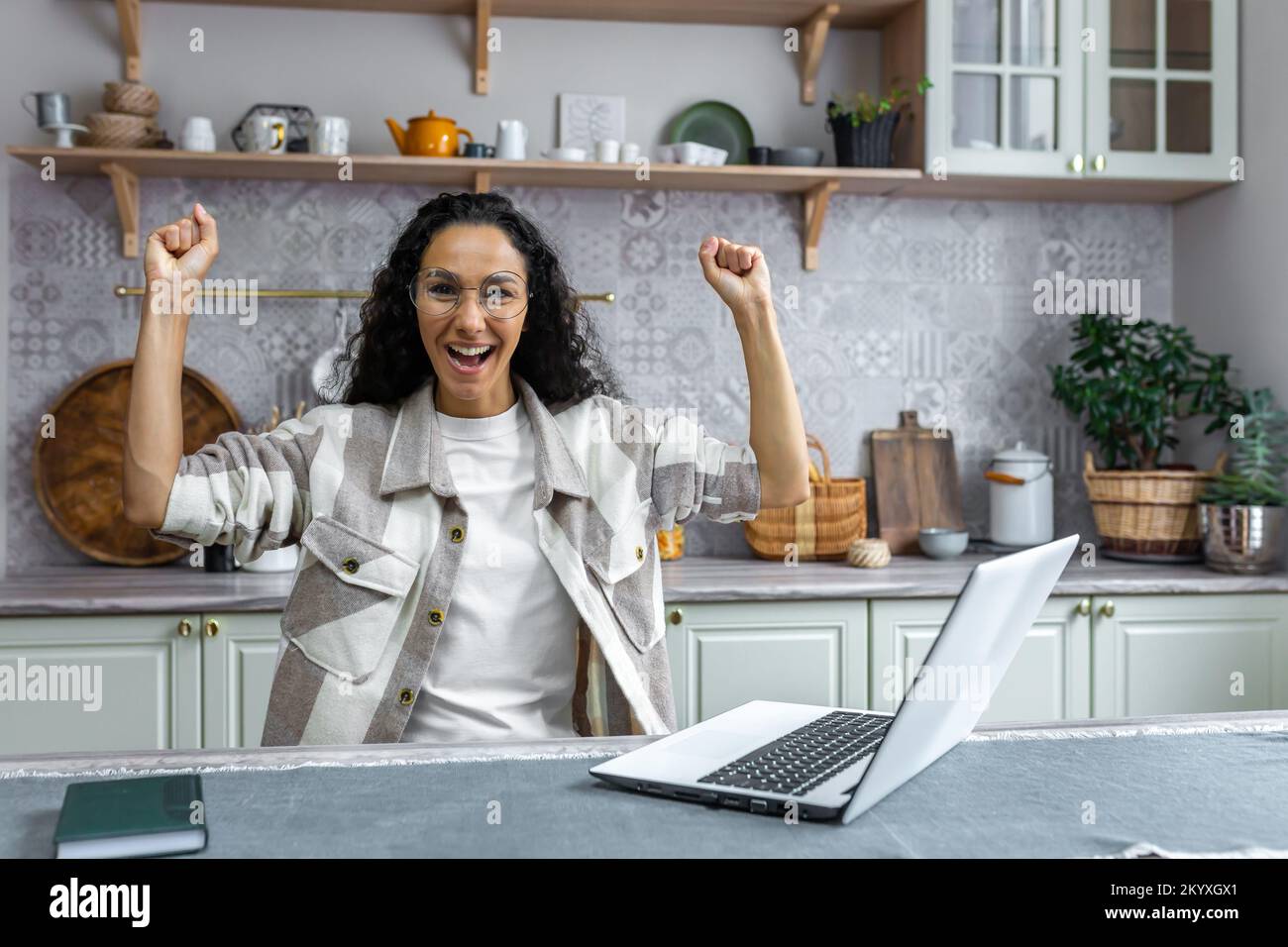 Happy young Latin American business woman with a laptop, sitting at ...