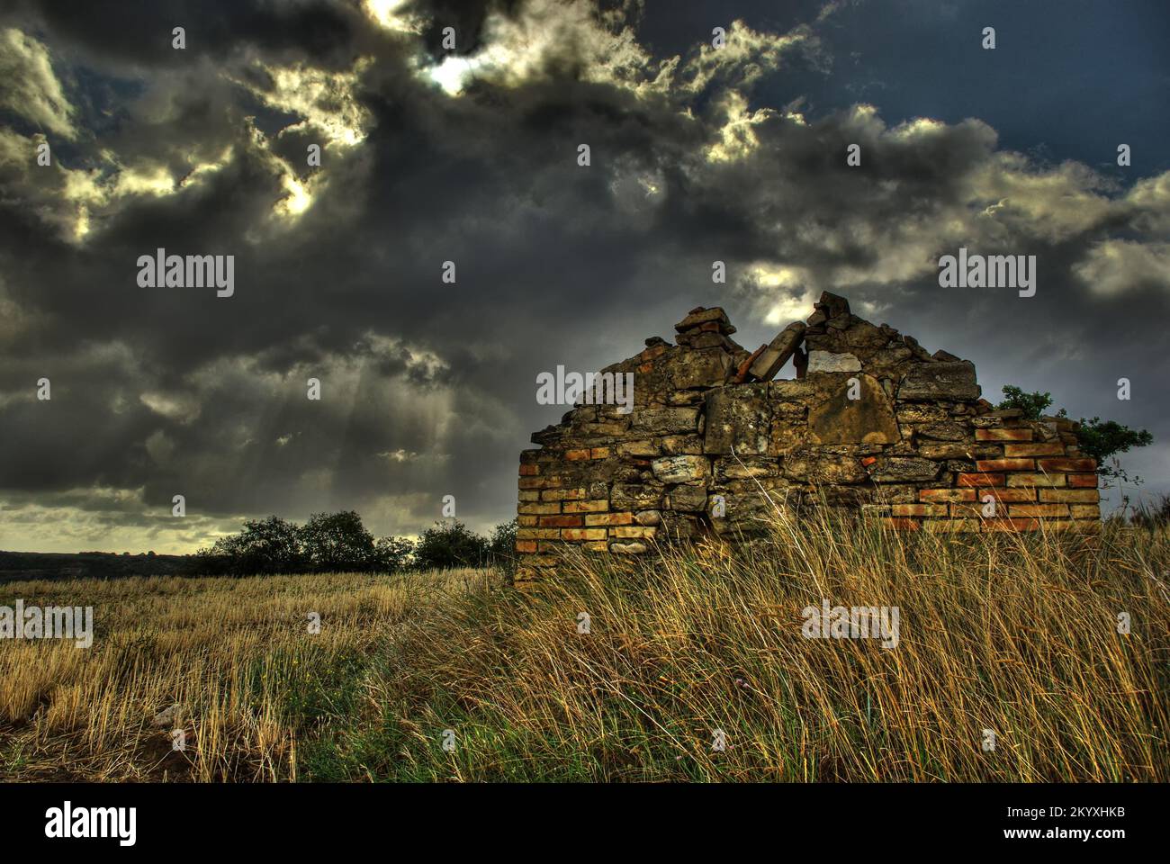 A dilapidated country house and the leaden sky in the background, a summer storm is coming Stock Photo