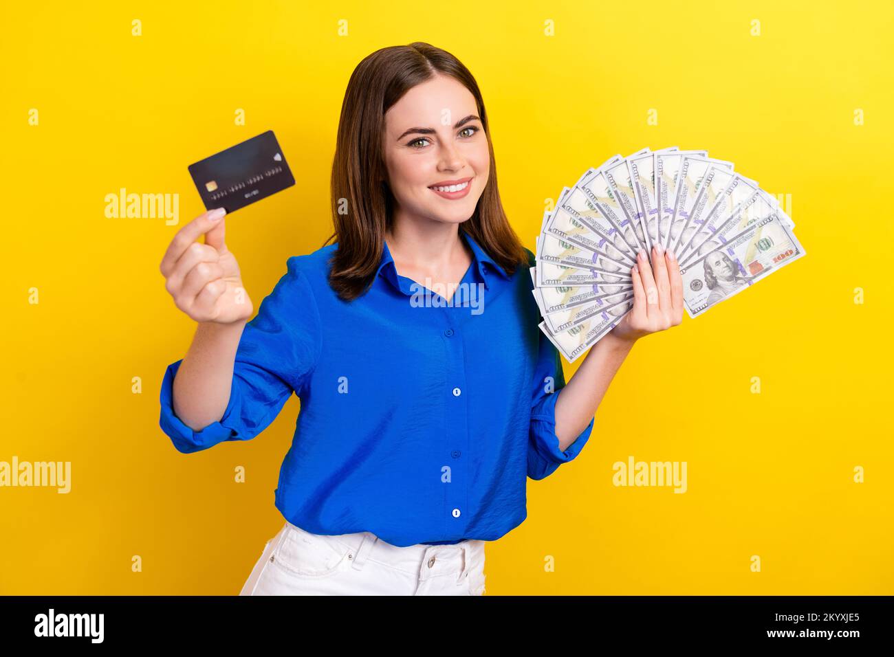 Photo of cheerful lovely lady office manager boss demonstrate plastic card cash got credit isolated on yellow color background Stock Photo