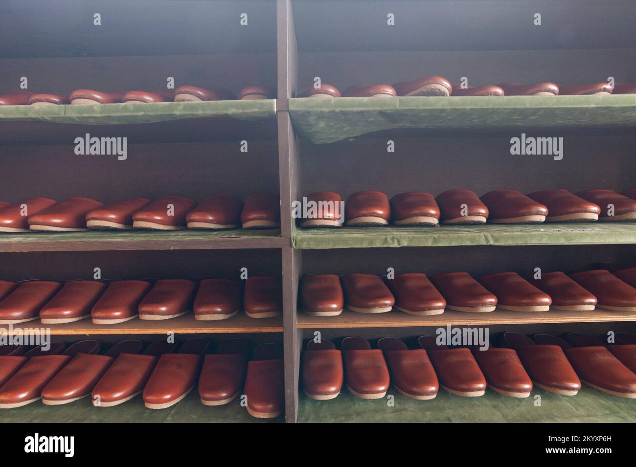 Slipper rack for visitors with rows of brown plastic slippers neatly arranged, at the Kaichi