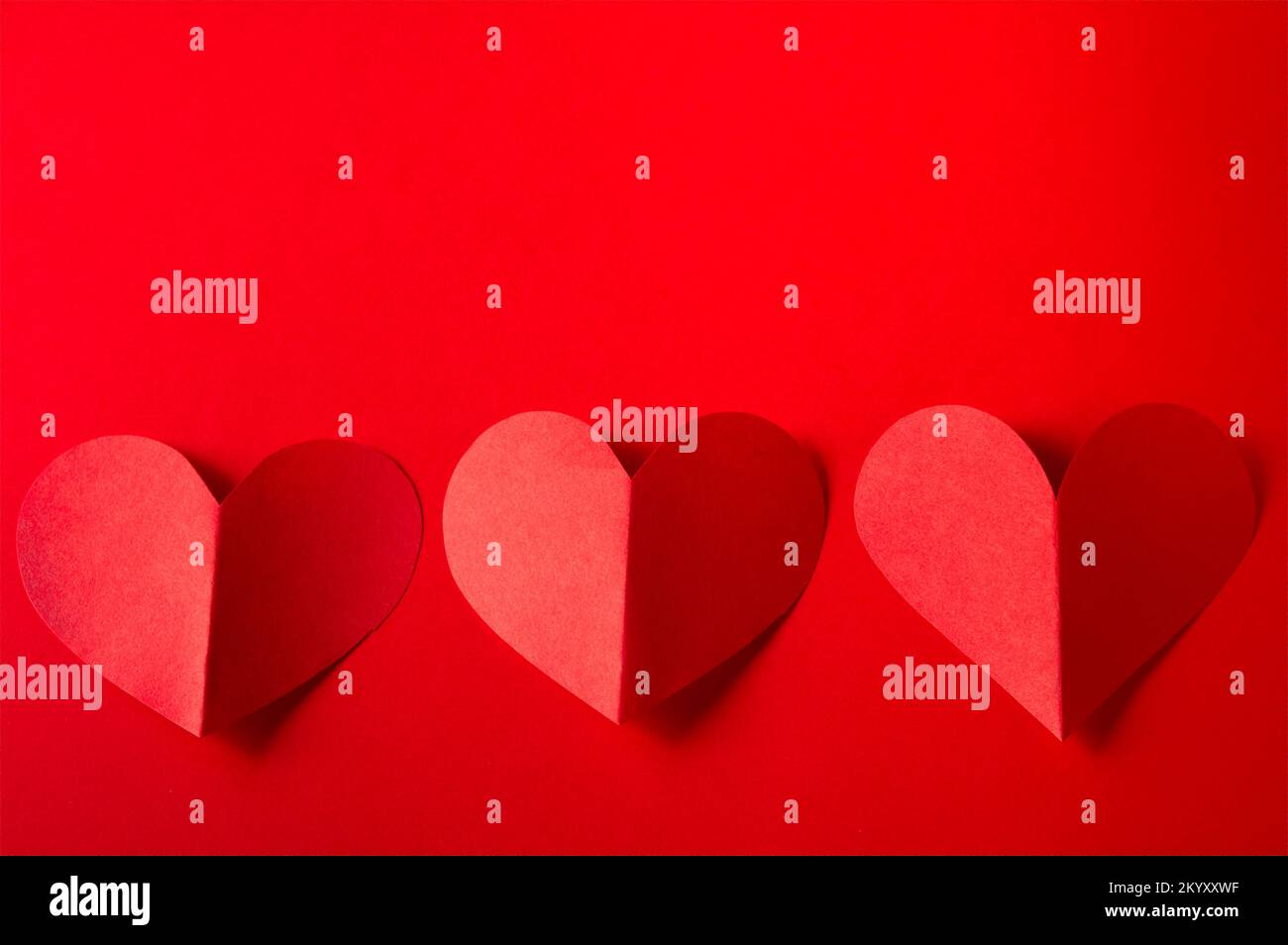 three red paper hearts on red background with copy space Stock Photo ...