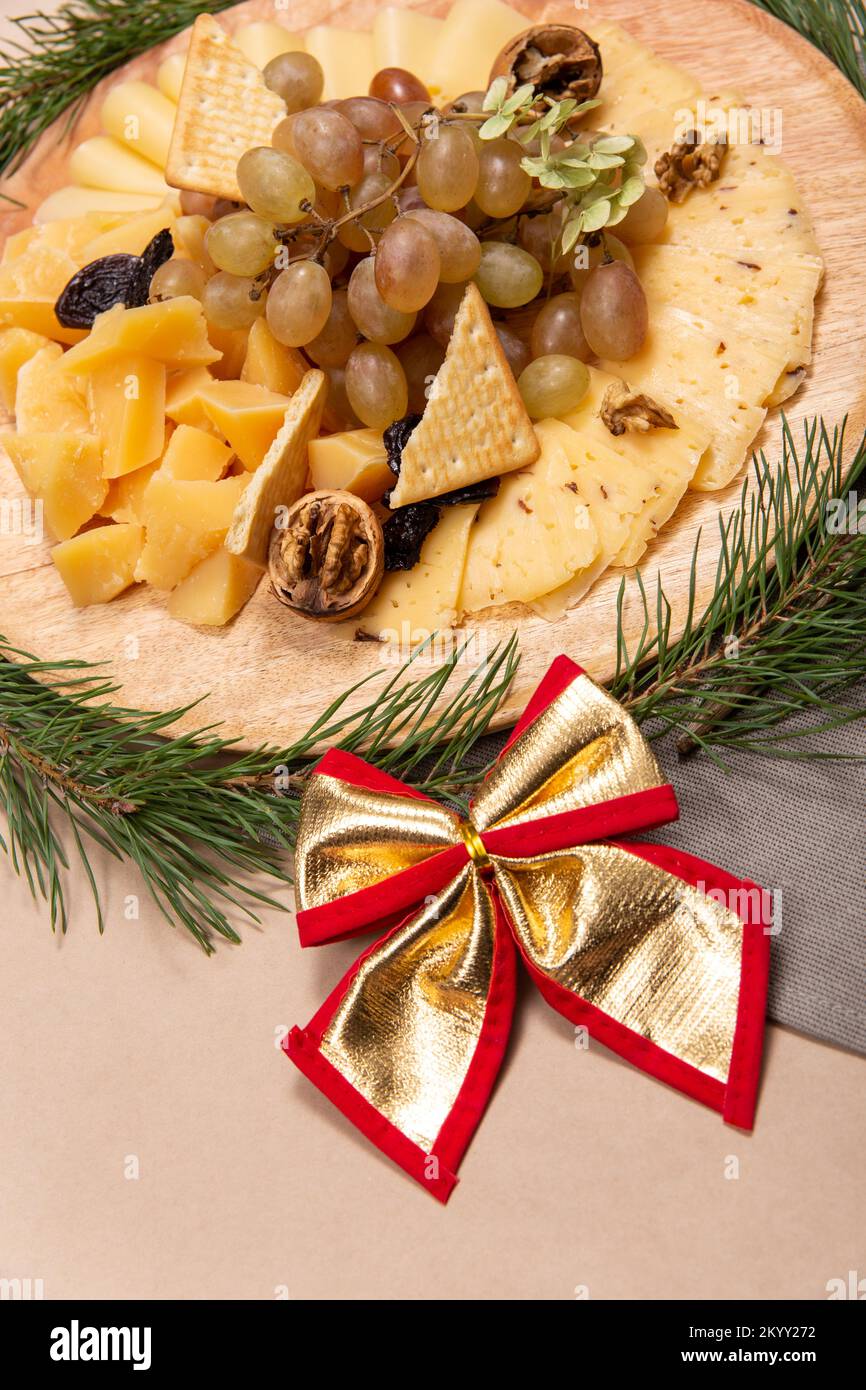 Christmas snacks on rustic wooden board with golen boa over paper