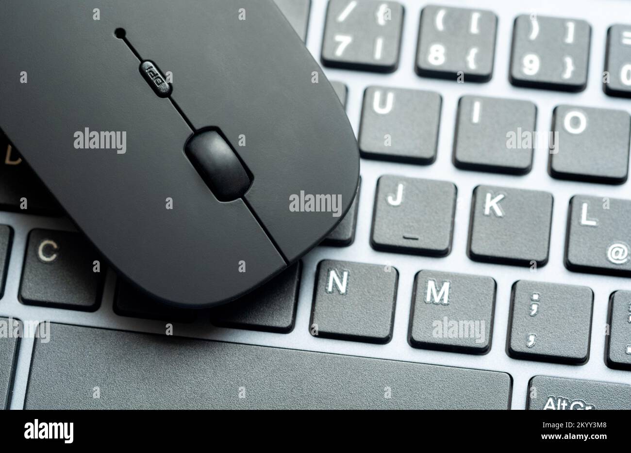 Modern flat office PC mouse laying on a computer keyboard, two objects ...