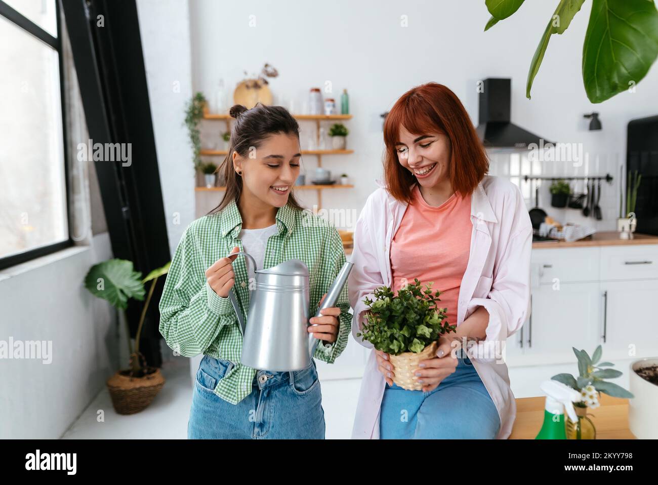 Women with a watering can and a houseplant Stock Photo