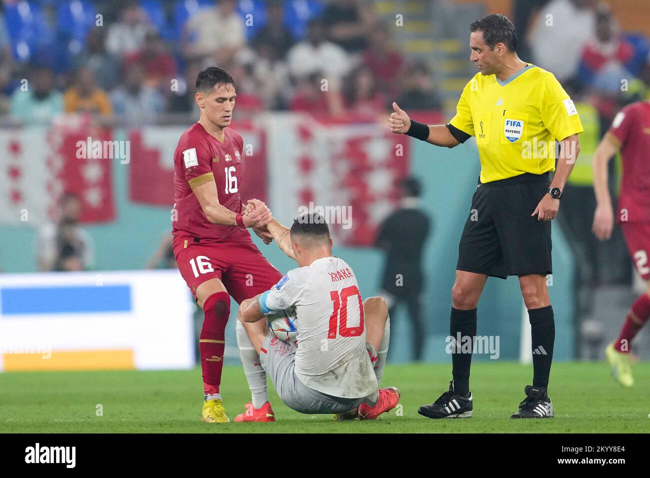 Doha, Qatar. 2nd Dec, 2022. Sasa Lukic (L) of Serbia helps Granit Xhaka of Switzerland up during the Group G match between Serbia and Switzerland at the 2022 FIFA World Cup at Stadium 974 in Doha, Qatar, Dec. 2, 2022. Credit: Zheng Huansong/Xinhua/Alamy Live News Stock Photo