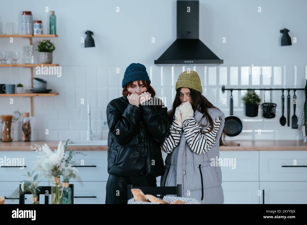 Warmly dressed women are upset with the heating turned off Stock Photo