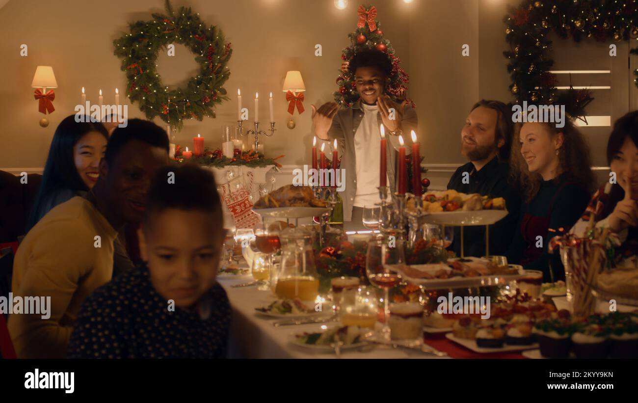 African American man givs gift to young boy. Happy family celebrating