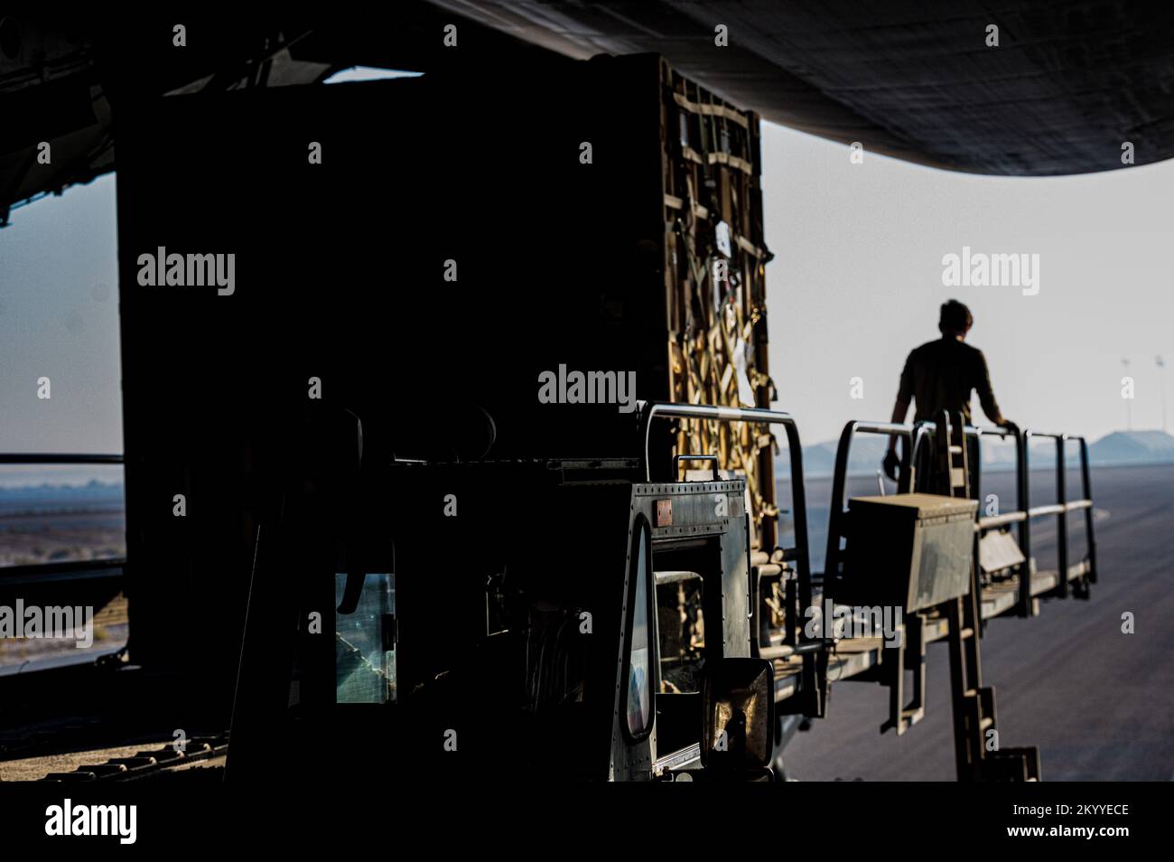 A U.S. Air Force Airman from the 380th Expeditionary Logics Readiness Squadron marshals cargo out of the rear loading ramp of a U.S. Air Force C-5 Super Galaxy aircraft at Al Dhafra Airbase, United Arab Emirates, December 1, 2022. (U.S. Air Force photo by 1st Lieutenant Alexandra Smith) Stock Photo