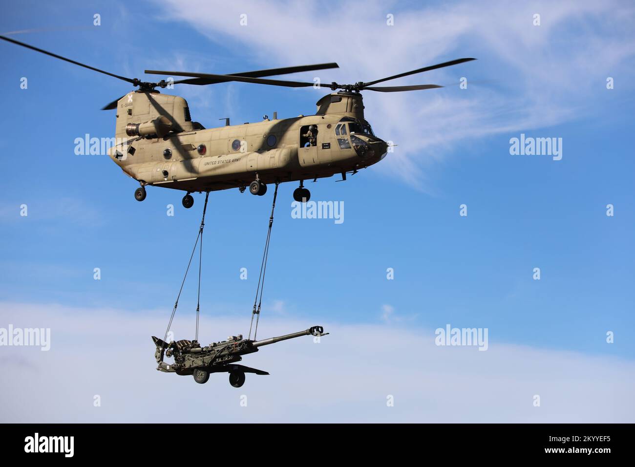 CH-47 Chinook from the 25th Combat Aviation Brigade carries a M777 Howitzer from the 25th Infantry Division Artillery (DIVARTY) at the Pohakuloa Training Area in Hawaii. Stock Photo