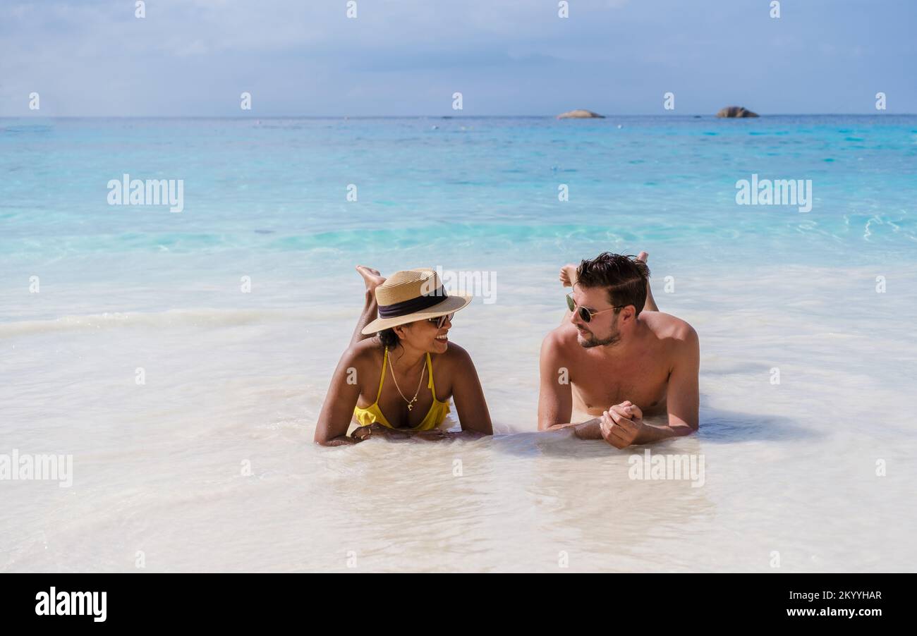 a couple of men and women sunbathed on the Similan Islands beach in Thailand.  Stock Photo