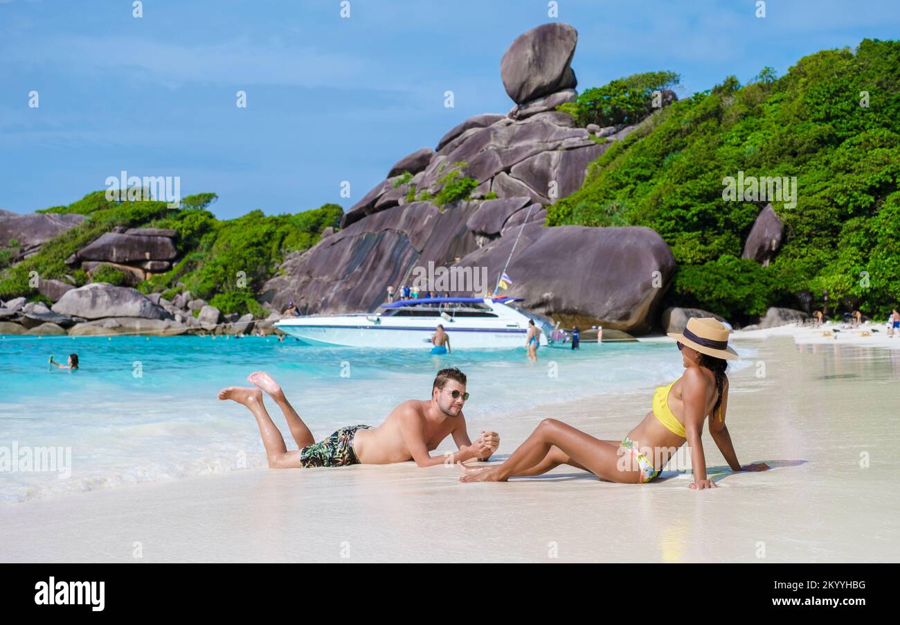 a couple of men and women sunbathed on the Similan Islands beach in Thailand.  Stock Photo