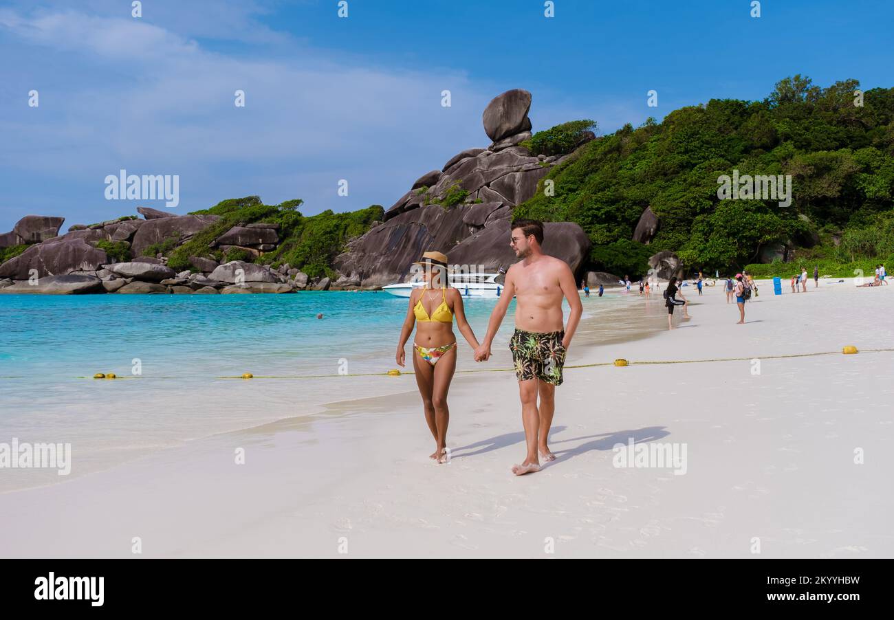 A couple of men and women are walking on a tropical beach in Thailand, Similan Islands.  Stock Photo