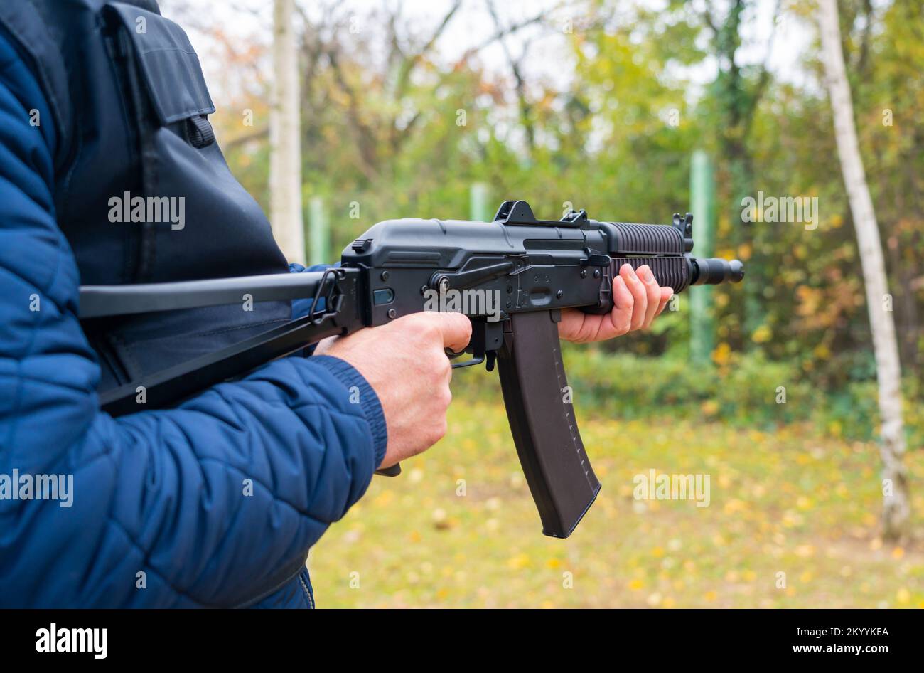 A man holds a machine gun for shooting from the hip Stock Photo