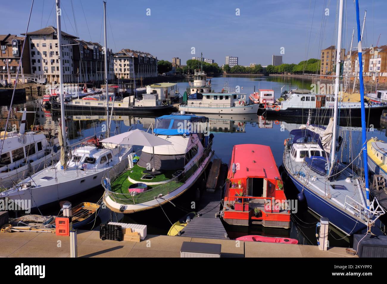 Greenland Dock at Surrey Quays marina with boats and reflections in Rotherhithe, London, England