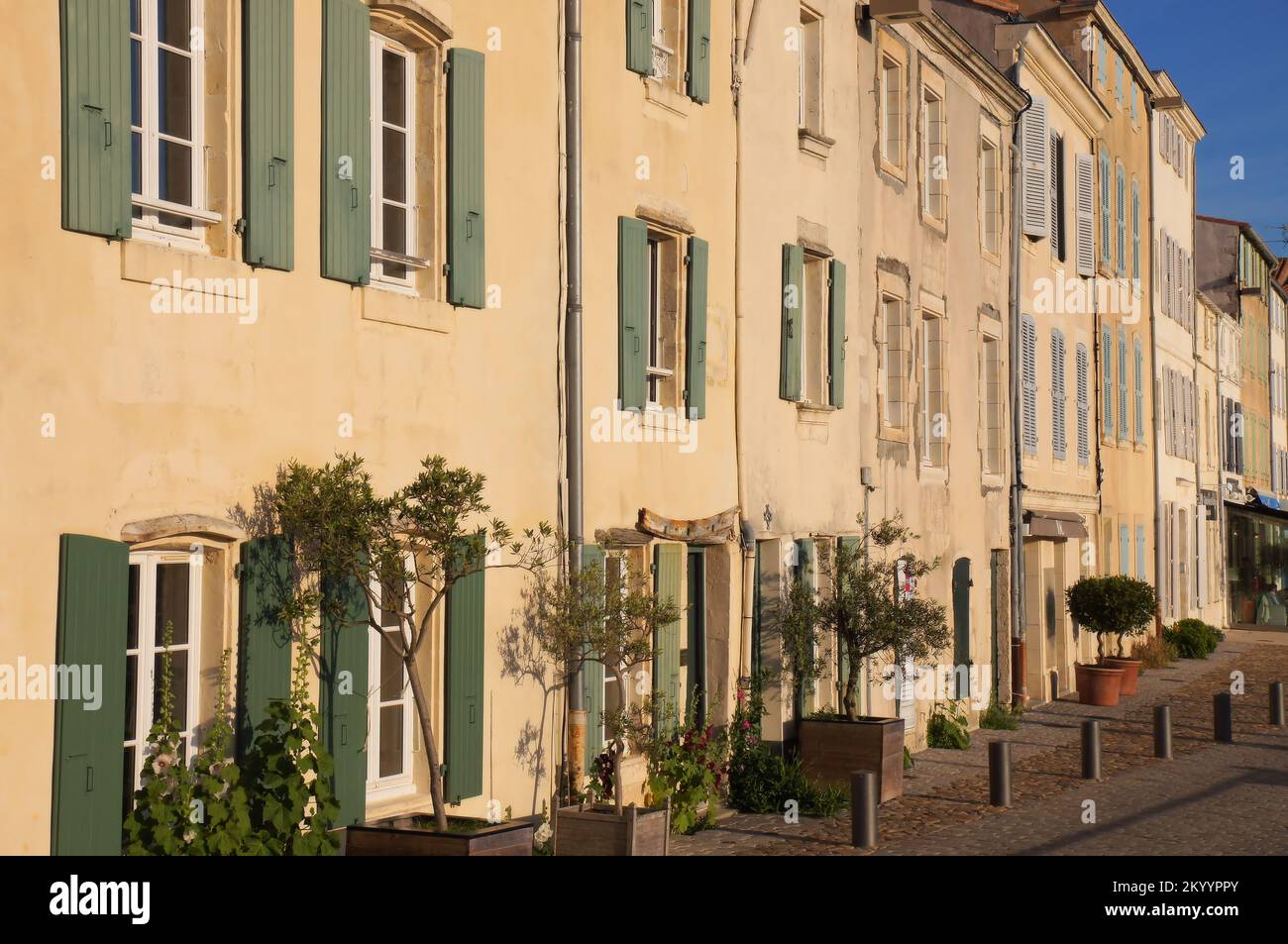 Buildings lining the port glowing gold soon before sunset at Saint-Martin-de-Ré, Ile de Ré, Charente-Maritime, France Stock Photo