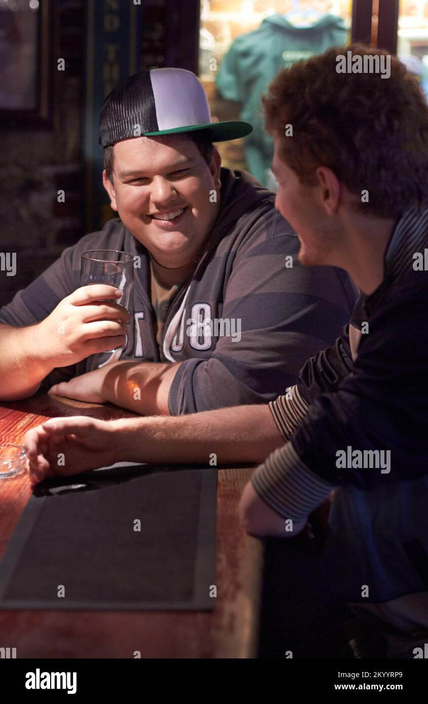 Having a pint with his pal. Two friends enjoying a drink at the local