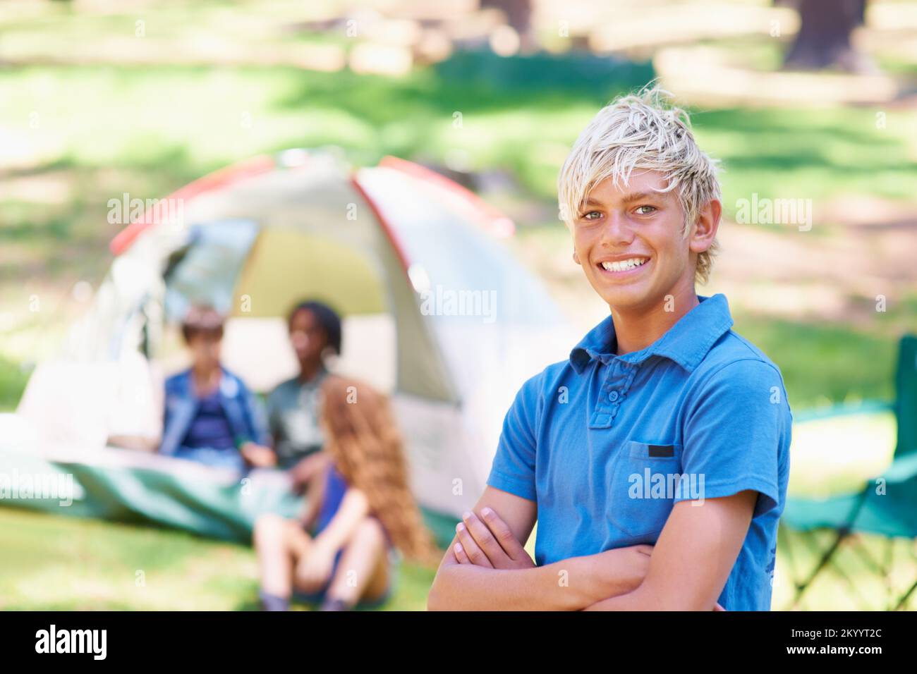 Claiming his camping spot. A boy standing in front of his campsite. Stock Photo