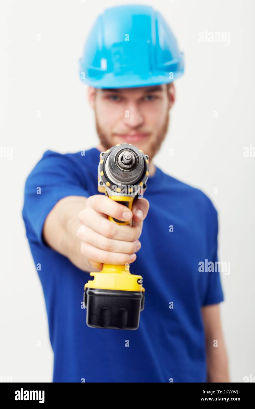 Promoting power tools. Portrait of a young man wearing a hardhat and holding a power drill. Stock Photo