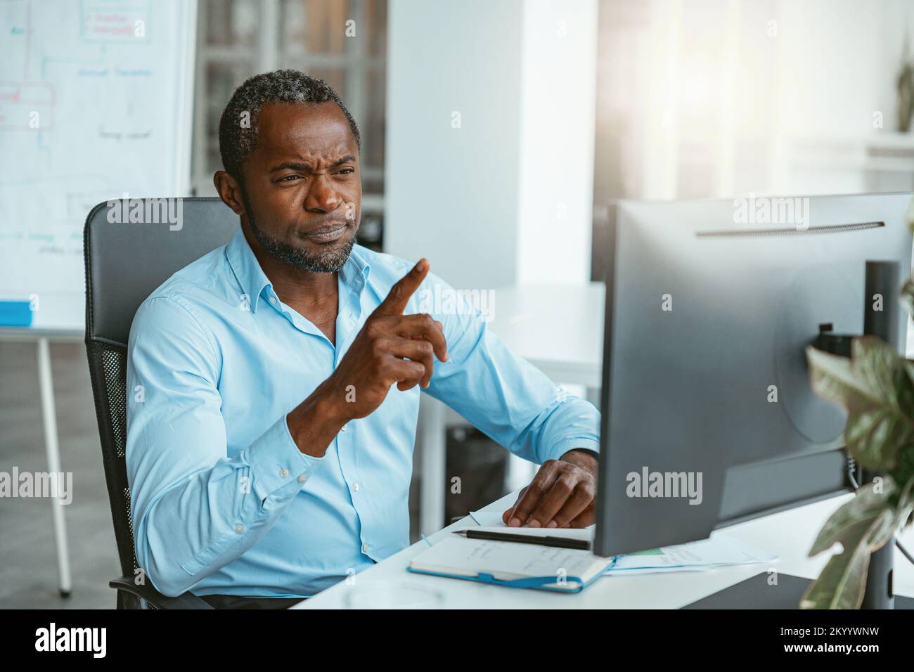 Busy african businessman working on computer while sitting in modern coworking Stock Photo