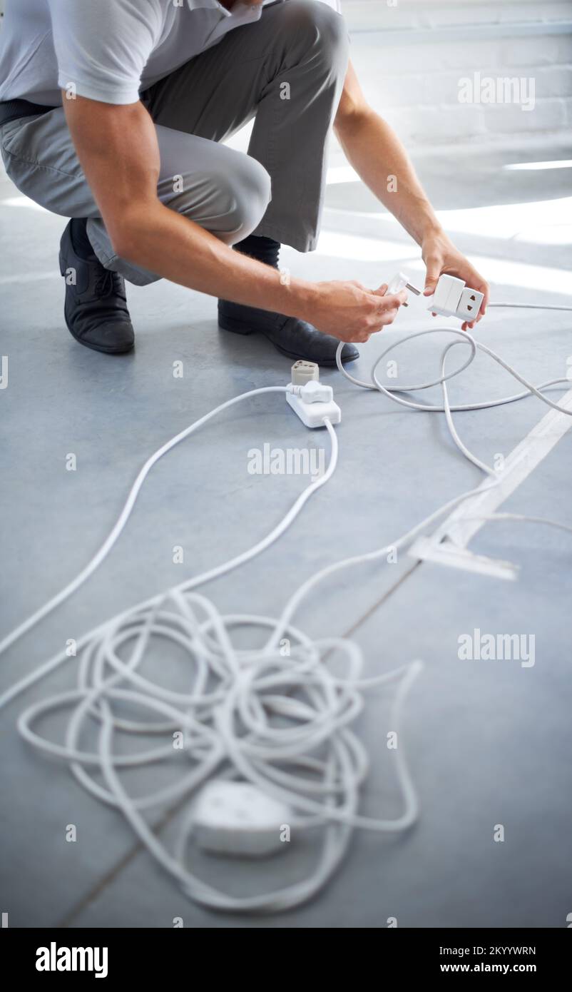 Giving your connection greater distance. A young man plugging something in. Stock Photo