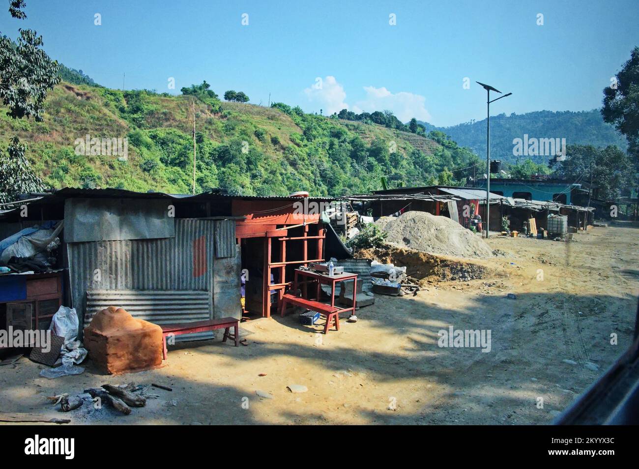 View from the bus window on the road in Nepal with small dilapidated houses Stock Photo