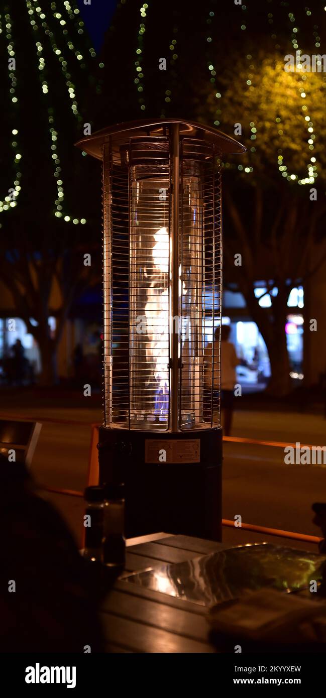 Tall stainless steel outdoor  propane table heater, sitting on top of a restaurant table Stock Photo