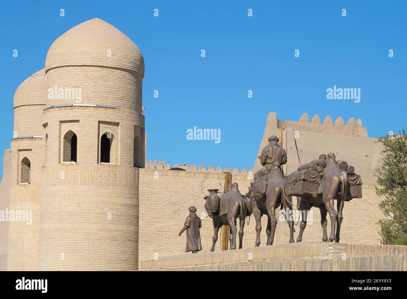 KHIVA, UZBEKISTAN - SEPTEMBER 05, 2022: The sculptural composition of Caravan at the walls of the Ichan-Kala inner city on a sunny day Stock Photo