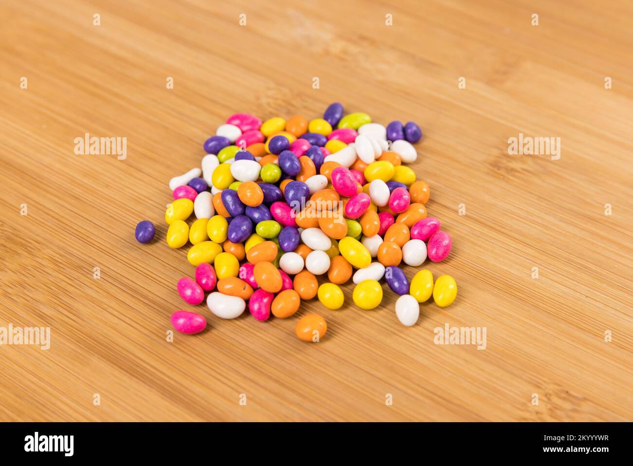 Fennel seed candy in a pile on a wood cutting board side view Stock Photo Alamy