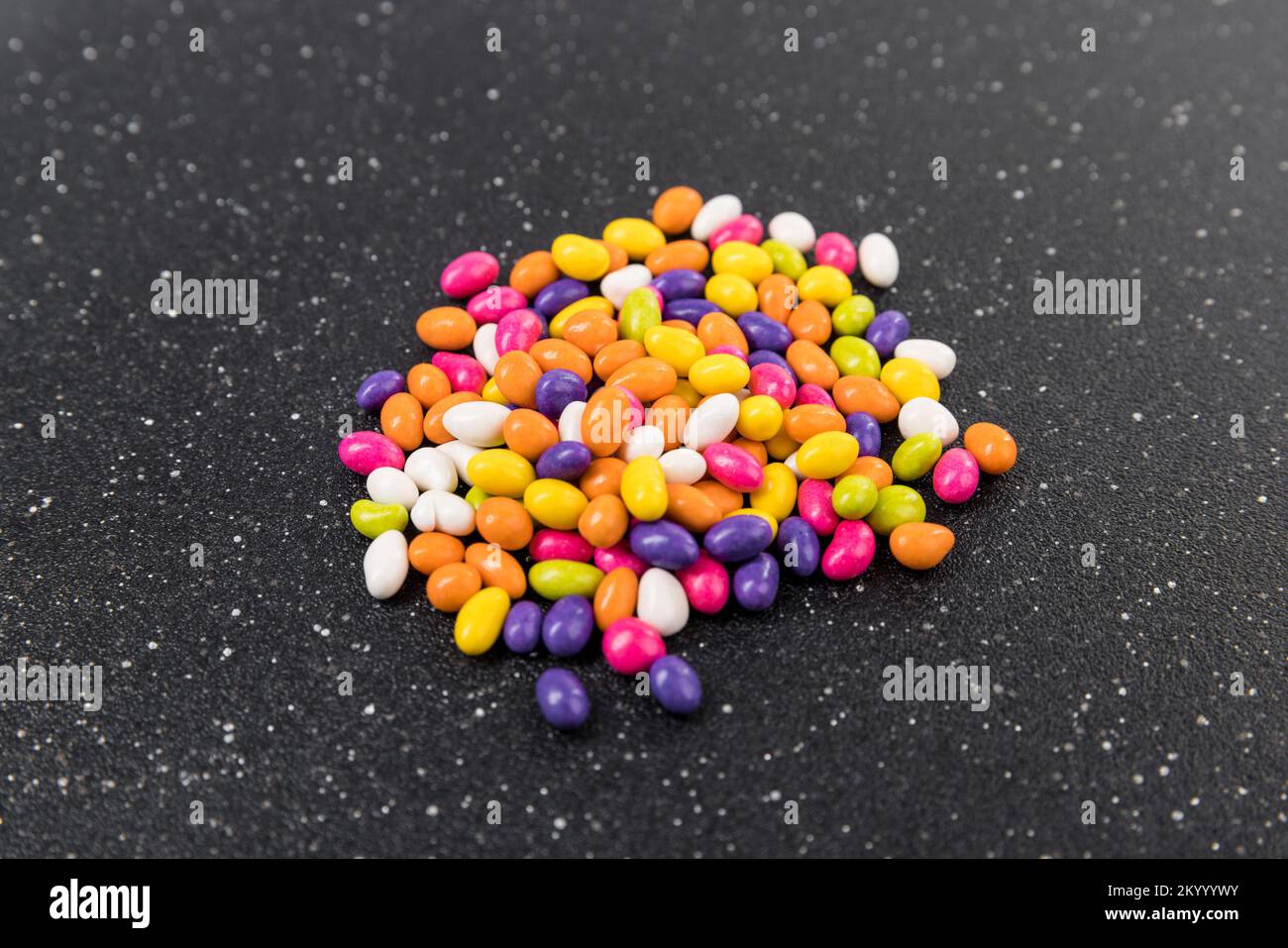 Fennel seed candy in a pile on a black cutting board side view Stock Photo Alamy