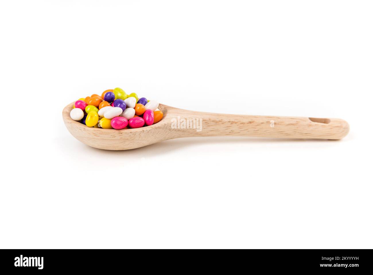 Fennel seed candy in a wooden spoon isolated over white Stock Photo Alamy