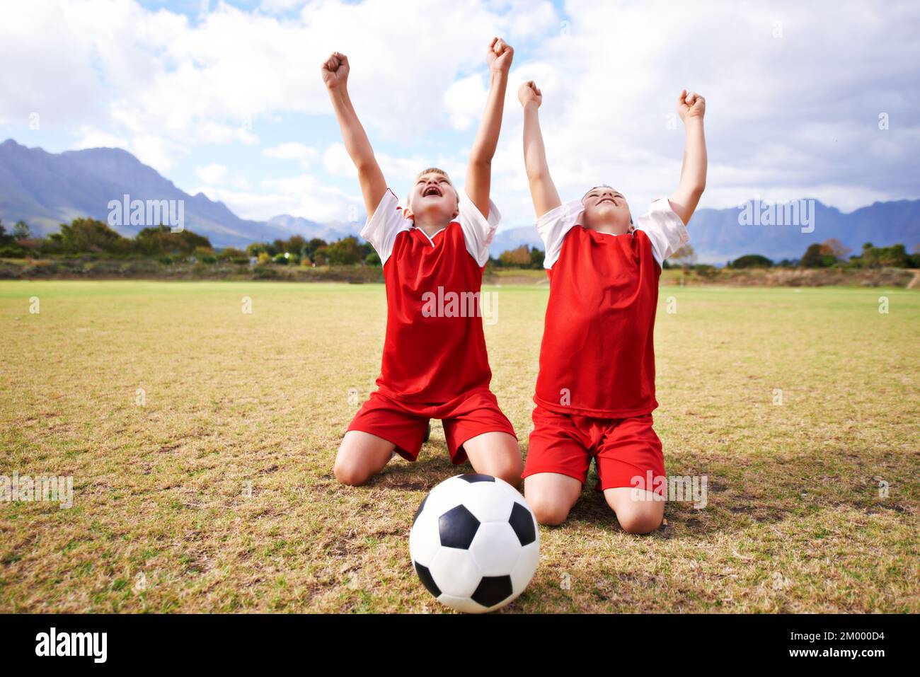Practicing their goal-scoring celebrations. Full length shot of two kids celebrating on a soccer field. Stock Photo