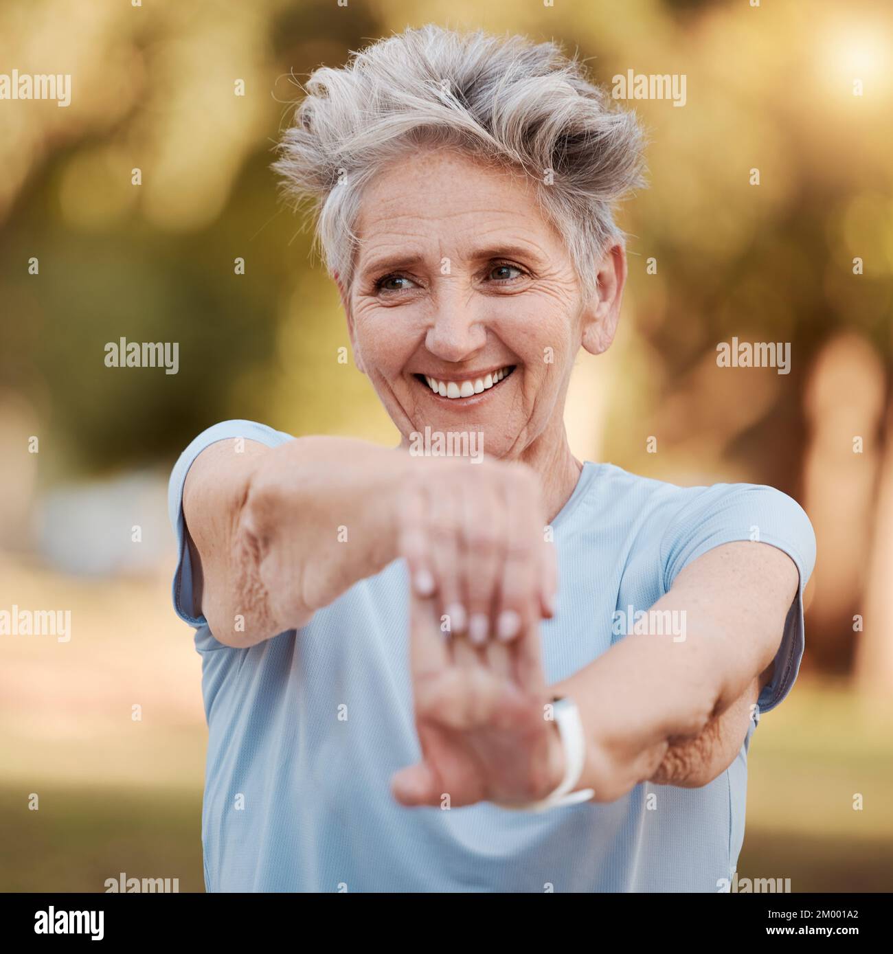 Happy old woman stretching in nature in fitness training, body exercise or workout for wellness balance. Smile, relaxing or face of healthy senior Stock Photo