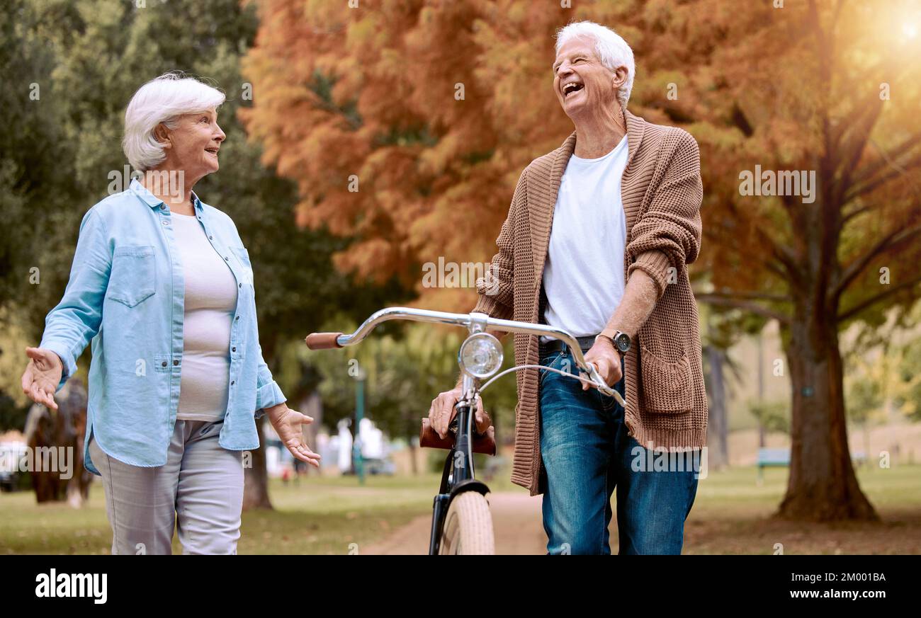 Elderly, couple and bike in the park for nature walk and exercise outdoor, senior man laugh at funny joke with old woman and eco friendly travel Stock Photo