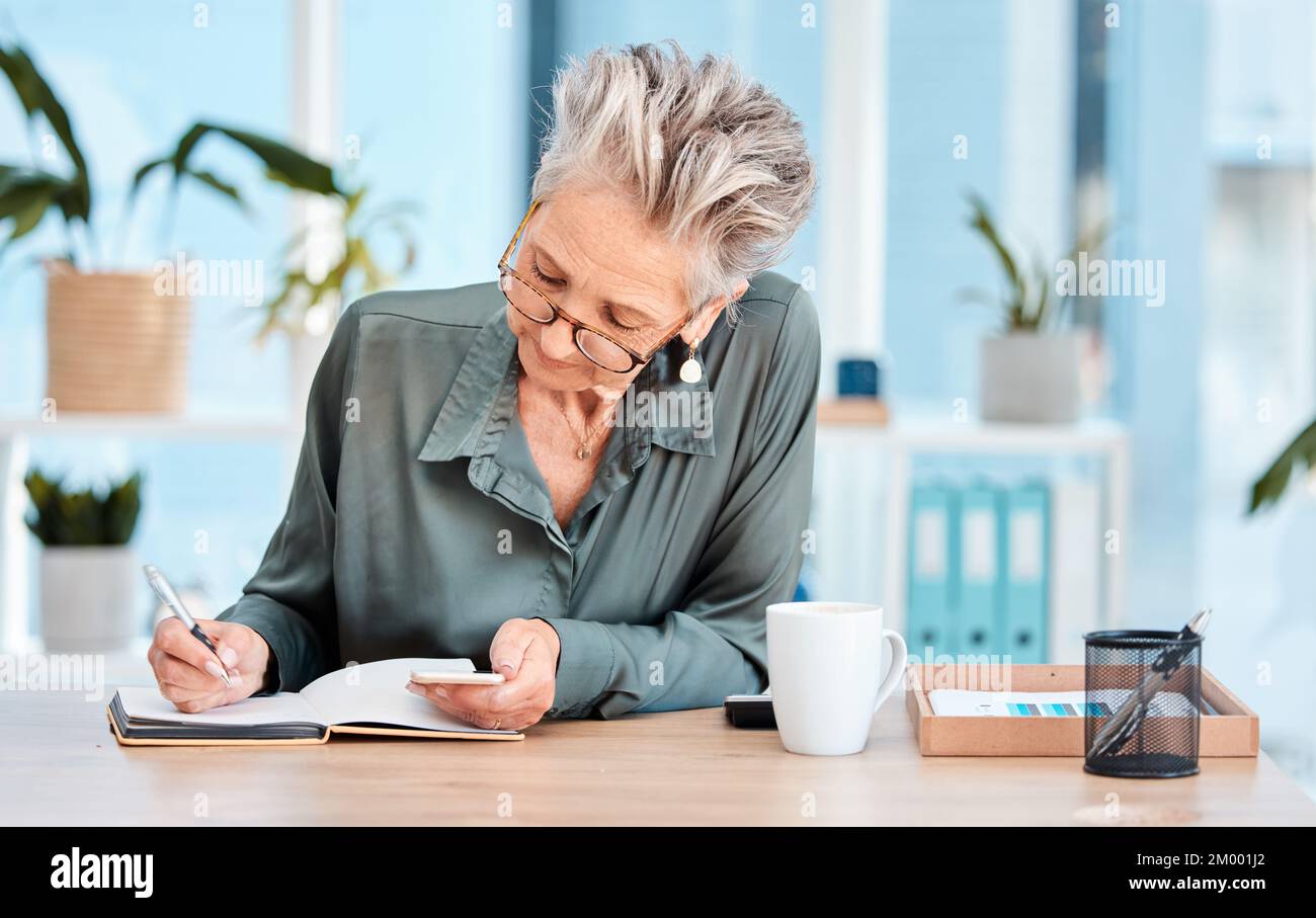 Writing, notebook and schedule with a woman ceo, manager or boss checking her diary for an appointment. Calendar, coffee and notes with a senior Stock Photo